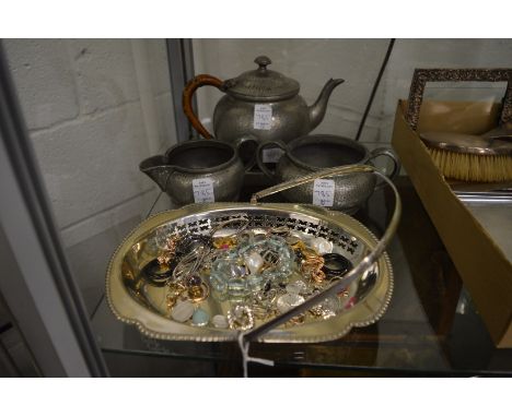 A plated basket, bijouterie and a pewter three piece tea service.
