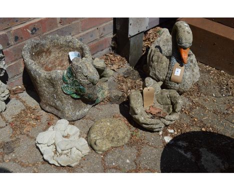 A reconstituted stone garden planter modelled as a swan together with other decorative items.