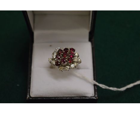 An 18ct white gold diamond and ruby cluster ring.