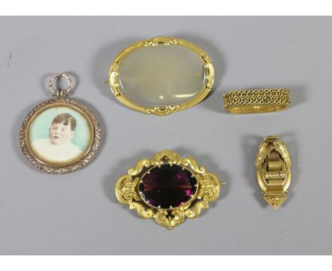 Five pieces of Victorian yellow metal jewellery including a scarf clip, amethyst brooch, agate brooch, portrait pendant and a