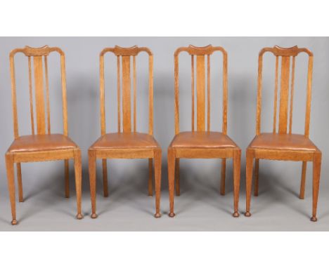 A set of four Edwardian light oak slat back dining chairs. Raised on square tapering supports terminating on onion feet. Cond