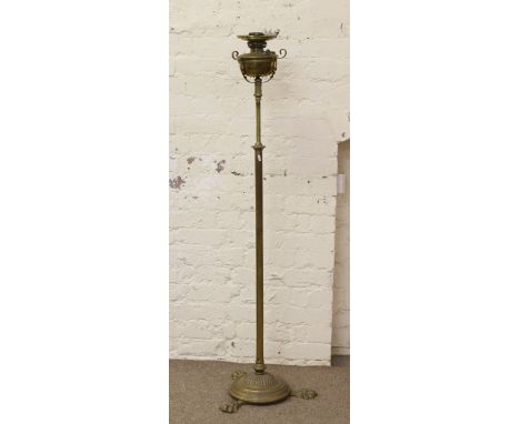 A Victorian brass rise and fall oil lamp raised on paw feet. 