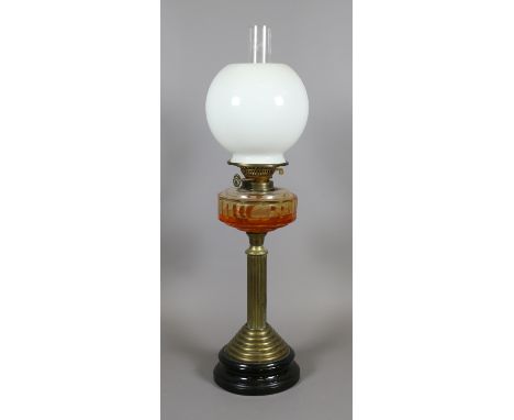 A Victorian brass oil lamp with milk glass shade raised on reeded column base.