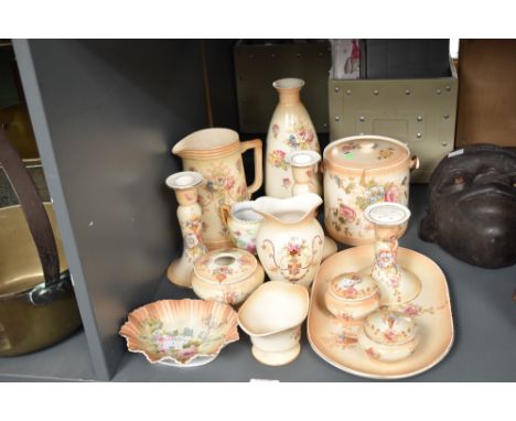 A quantity of Ducal ceramic wares, decorated with floral patterns on a blush ivory ground, to include a pair of candlesticks,