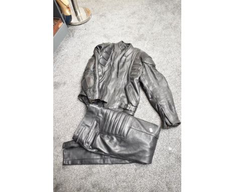 A leather motorbike jacket, size 44, sold together with a pair of leather trousers, size 32 waist