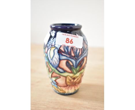 A Moorcroft pottery 'Geneva' pattern vase designed by Phillip Gibson, having tube lined decoration and painted marks to base,