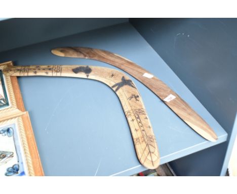 An Australian wooden boomerang having carved figures and traditional aboriginal patterns, L51cm, sold together with another b