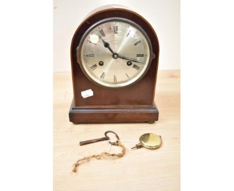An early 20th century Wales and McCulloch 8 day mahogany mantle clock, having arched top decorated with inlay edging, the fac