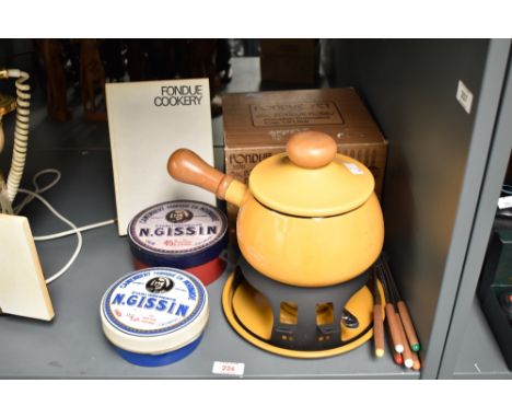 A yellow enamele fondue set, cap 1.9L, sold together with a ceramic N.Gissin dish with cover and a fondue cookery book ect, (