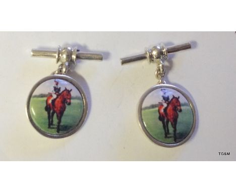A pair of silver and enamel set cufflinks with horse and rider