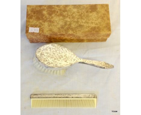 A silver musical hairbrush and comb set
