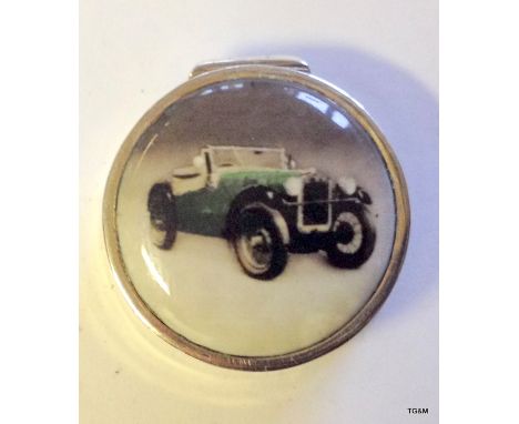 A silver and enamel pill box depicting a classic car