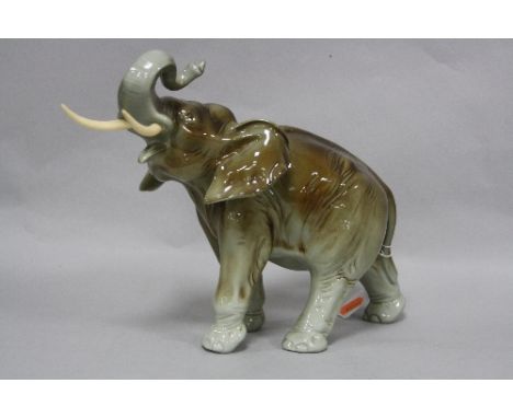 A ROYAL DUX ELEPHANT, trunk raised, height approximately 24cm x length approximately 34cm (including tusks)