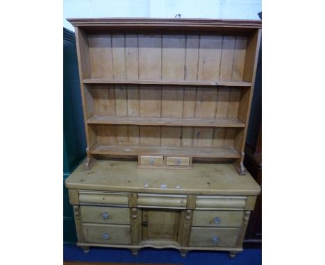 A VICTORIAN PINE DRESSER BASE, with central cupboard and seven various drawers, the later plate rack with two spice drawers, 