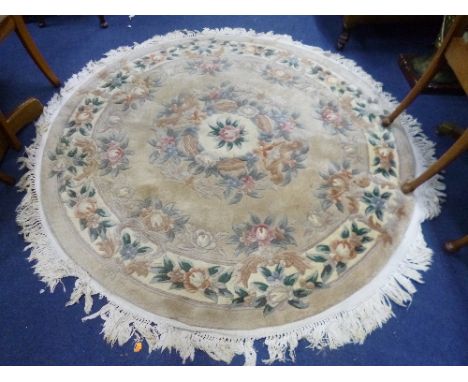 A CIRCULAR FAWN GROUND FLORAL RUG, approximate diameter 165cm and a tall floor standing urn shaped lamp (s.d.) (2)