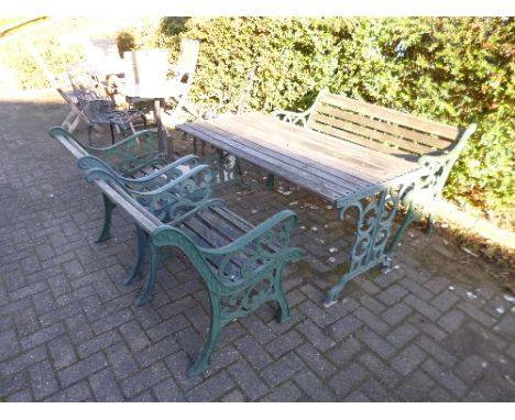 A FOUR PIECE CAST IRON GARDEN SET, comprising of a table, two seater bench and a pair of armchairs, all with timber slats and