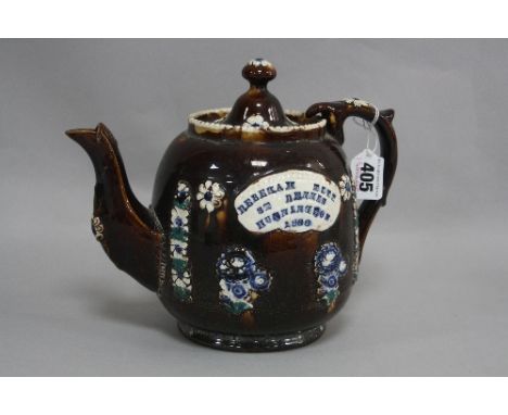 A SMALL MEASHAM BARGEWARE TEAPOT, treacle glazed with applied foliage and plaque 'Rebekah Pitt, St Dennes, Hunnington 1888' (