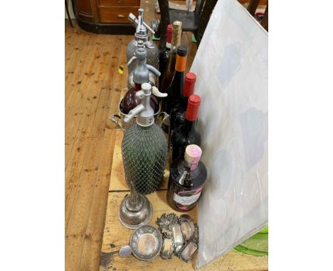 Four vintage soda siphons, wine and gin labels, wine funnel and taster.