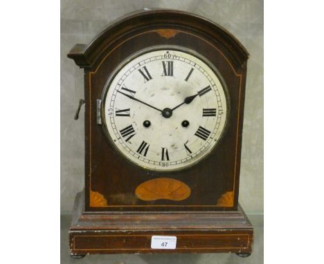 An inlaid mahogany manual wind striking mantle clock