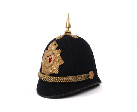A post 1902 OR's home service helmet of the Royal Guernsey Light Infantry, blue cloth with brass mounts, in  above average GC