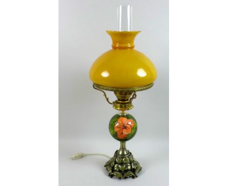A Moorcroft table lamp, in the form of a Victorian oil lamp with 'Hibiscus' pattern globe body, orange glass shade and clear 