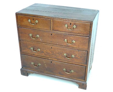 A Georgian oak chest of two short over three long graduating drawers, with caddy top and brass swan neck handles, raised on b