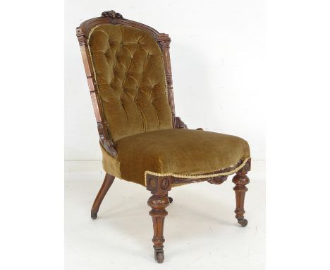 A Victorian nursing chair, green velvet upholstered seat and button back, carved mahogany frame, 55 by 70 by 96cm high. 