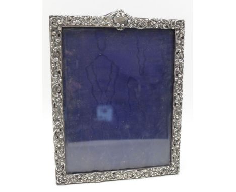 A LATE VICTORIAN EMBOSSED SILVER MOUNTED PHOTOGRAPH FRAME, having blind cartouche to the crest, original blue velvet back wit