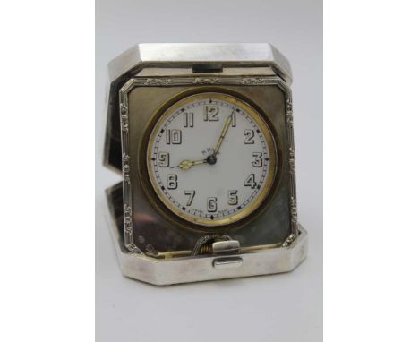 GOLDSMITHS &amp; SILVERSMITH'S CO. LTD, A SILVER CASED TRAVEL CLOCK, hinged form with bounds reed edge, London 1924, the 8-da