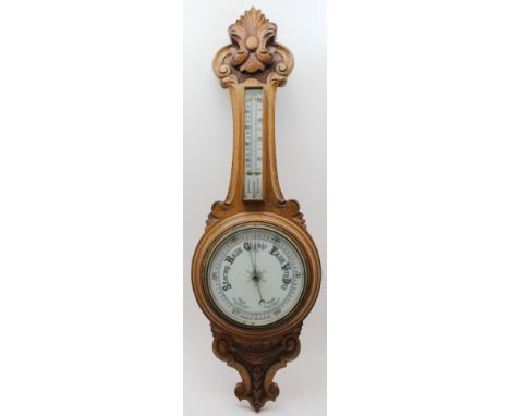 A LATE VICTORIAN CARVED OAK FRAMED BAROMETER with thermometer to the neck, the main dial 19cm, overall 91cm high 
