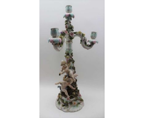 A SITZENDORF PORCELAIN CANDELABRA, putti mounted stem, rose encrusted, fitted a triple branch, four light candle branch top, 