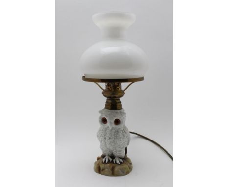 A LATE 19TH CENTURY CONTINENTAL OWL LAMP, converted from oil to an electric lamp, the white owl has inset glass eyes, fitted 