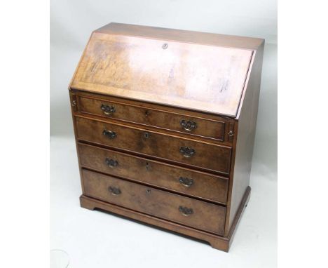 A GEORGE III WALNUT BUREAU, with fall-down writing slope revealing well fitted interior, over four graduating full width draw