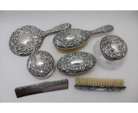 A VICTORIAN DESIGN SILVER MOUNTED SEVEN PIECE DRESSING TABLE SET comprising; hand vanity mirror, glass jar with silver cover,