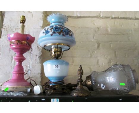 An oil style lamp with blue floral shade and body (electric), a pink glass lustre converted to electricity (a/f) and a carria