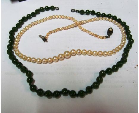 A pearl necklace with clasp marked silver and a jade necklace