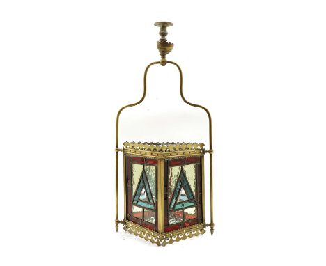 A Victorian brass hall lantern with stained glass panels, of square section with pierced gallery and apron, and a brass hangi