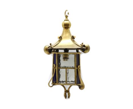 An Art Nouveau brass porch or hall lantern, with pagoda top and scroll side mounts, clear glass panels and blue glass angles,