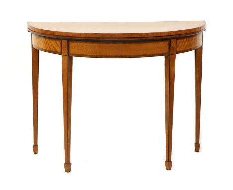 A George III satinwood and rosewood crossbanded card table, c.1790, of demi-lune outline, the folding top enclosing a baize-l