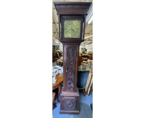 A Georgian oak cased longcase clock, the heavily carved case having turned columns flanking the brass 11" dial, the dial insc