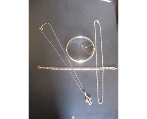 A selection of silver jewellery to include an engraved bangle, a Greek key decorated bracelet, a pendant in the form of a cro