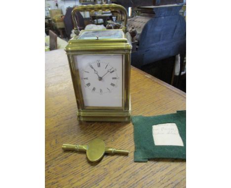 An early 20th century brass cased fire window, repeating carriage clock, with moon hands, white enamel Roman dial with Arabic