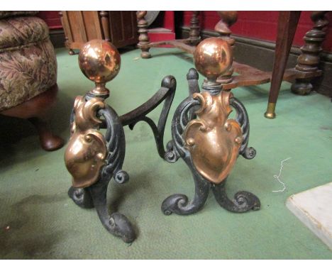 A pair of 19th Century copper and iron fire dogs with Art Nouveau style shield motif 