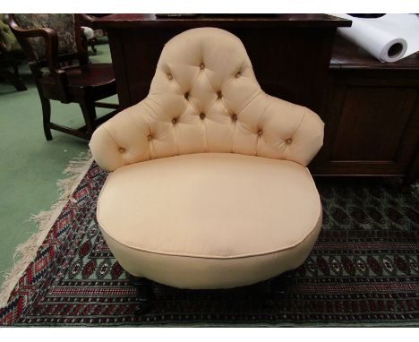 A late Victorian button back parlour chair on ebonised turned feet and ceramic castors 