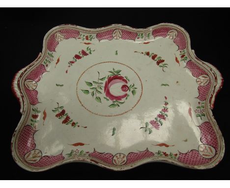 A late 19th/early 20th Century creamware two-handled tray of wavy rectangular form, painted in pink, green and iron red with 