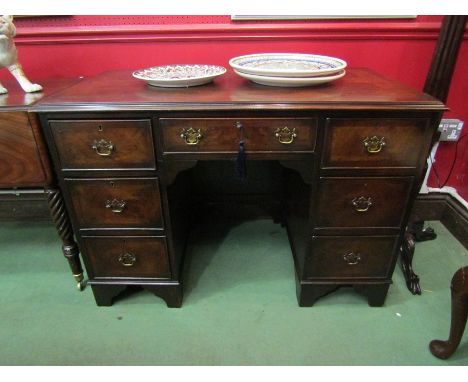 A George II style crossbanded figured walnut twin pedestal desk of seven drawers with working locks and key over bracket feet