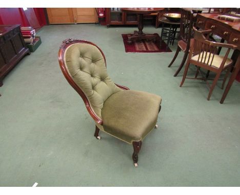 A circa 1860 walnut spoon-back armchair with carved floral decoration over a buttoned backrest and serpentine front seat on c