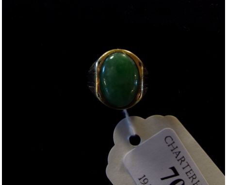 A large oval jade ring, in a yellow coloured metal mount