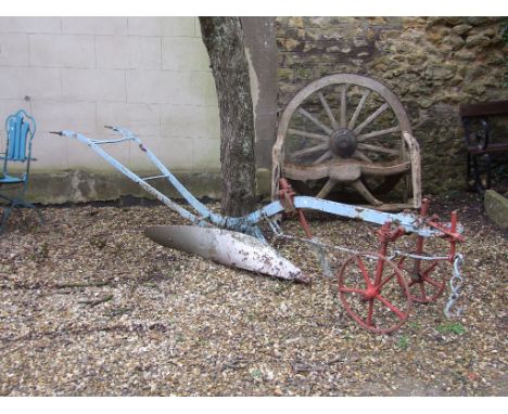 A late 19th century single plough, and a bench, made from a cart wheel (2)