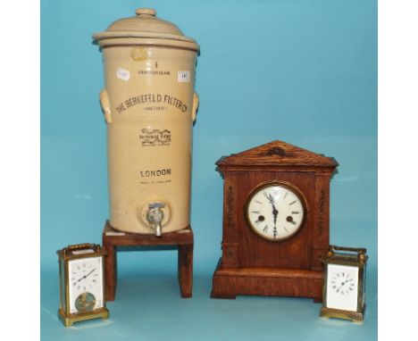 An oak mantel clock, 32 cm high, a carriage clock, in a four pillar brass case, a similar clock, and a Berkefeld Filter potte